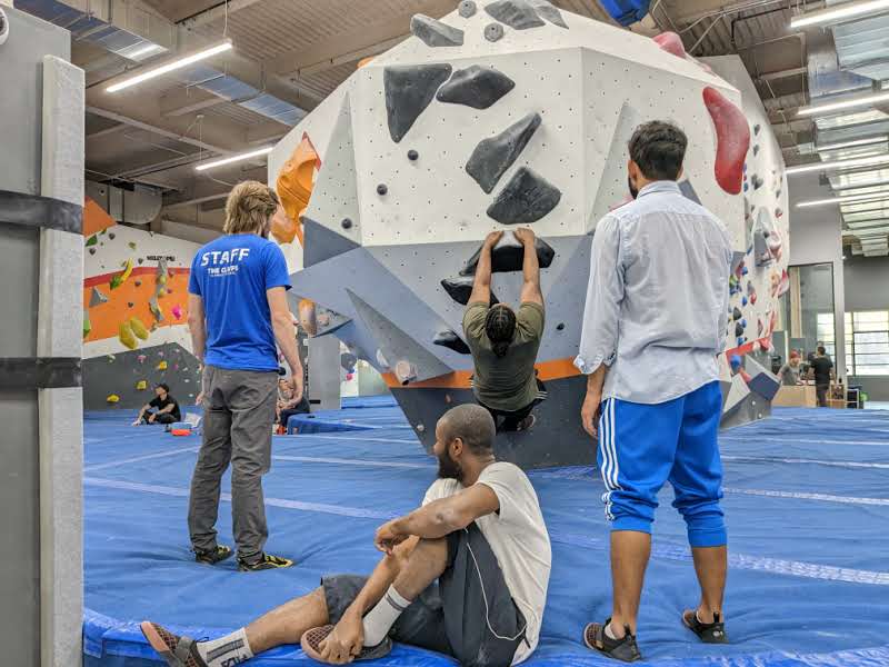 PhD students bouldering under guidance