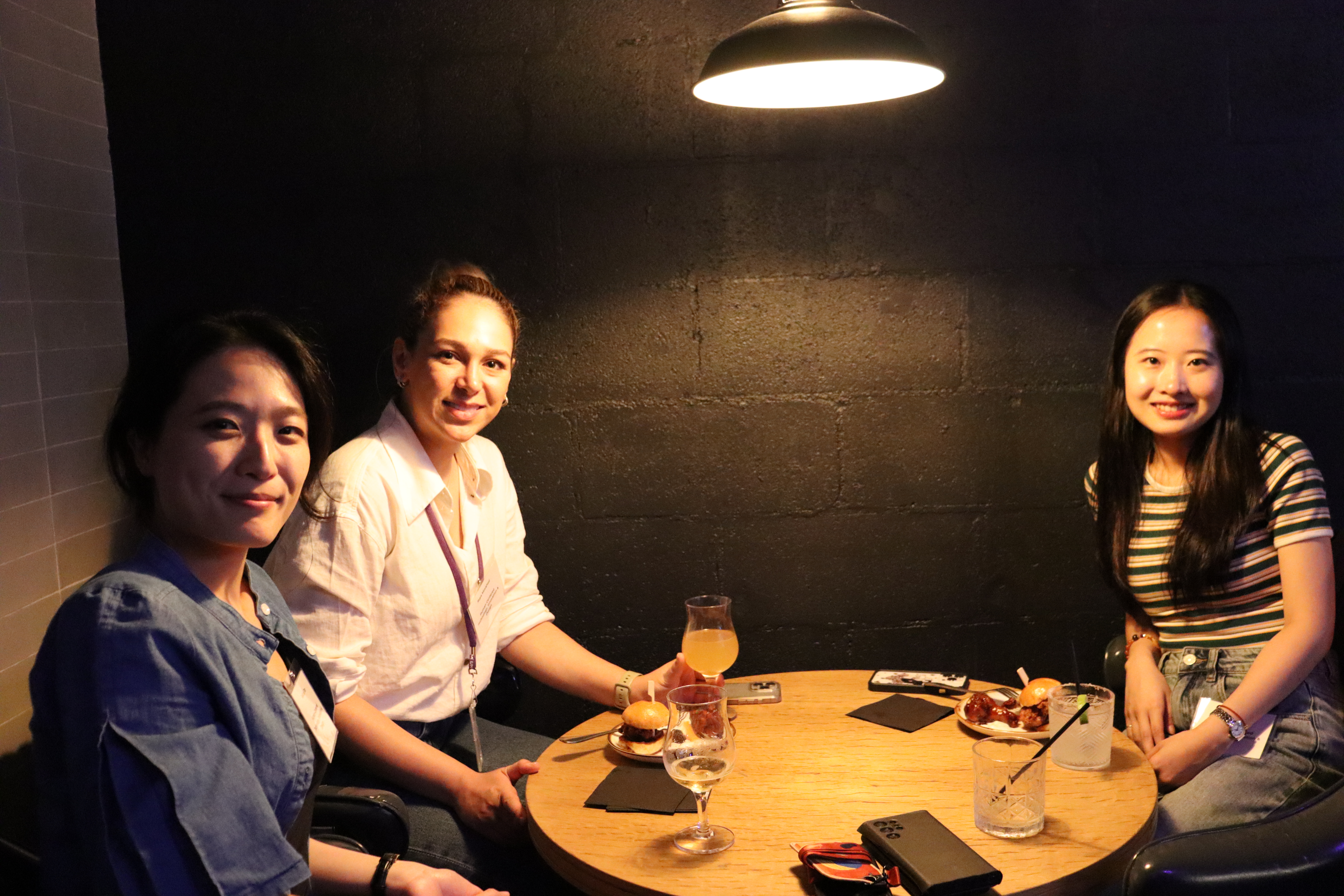 Group of PhD students chatting over food and drinks at the Fall 2024 Mixer